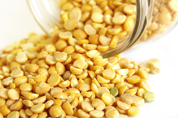 Yellow split peas in a glass jar on a slate