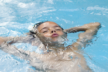 young boy relaxing in blue water