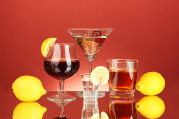 a variety of alcoholic drinks on red background