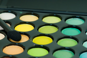 multicolored eye shadows with cosmetics brush