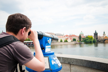 The man looks through telescope in Prague