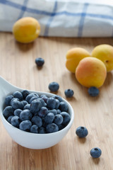 Blueberry and apricots on wooden table