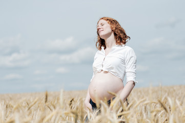 Fototapeta na wymiar Kobieta w ciąży w polu zbóż