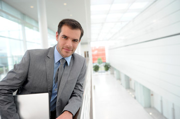 Businessman in grey suit standing in hallway