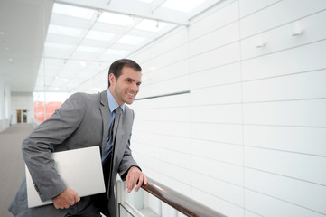 Businessman in grey suit standing in hallway