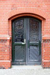 Porte verte sur façade rouge