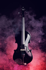 Elegant black violin in smoke