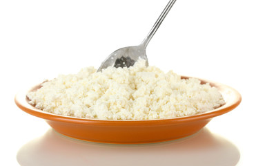 Spoon scoops of cottage cheese in a plate on white background