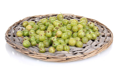 Green gooseberry on wicker mat isolated on white