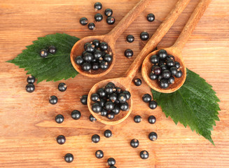 Fresh black in wooden spoons on wooden background close-up
