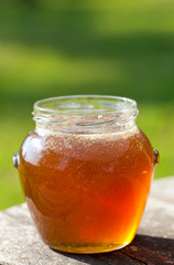 jar with honey on garden table
