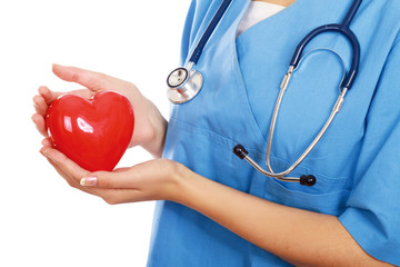 Female doctor with stethoscope holding heart