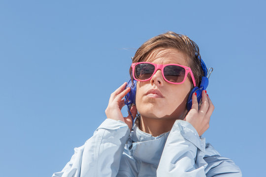 Girl listening to music with pink sun glasses