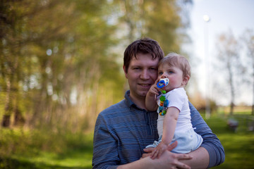 happy young father with his child in green forest