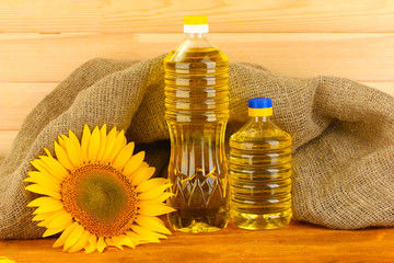 sunflower oil and sunflower on wood background