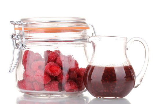 Raspberries in jar and jug with jam isolated on white