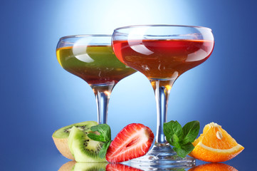fruit jelly in glasses and fruits on blue background
