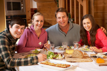 Teenage Family Enjoying Meal In Alpine Chalet Together