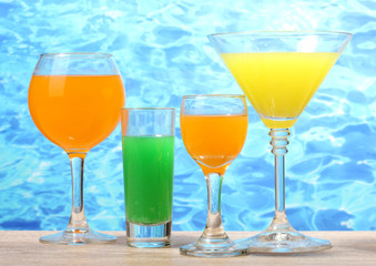 exotic cocktails on table on blue sea background