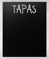 "Tapas" handwritten with white chalk on a blackboard