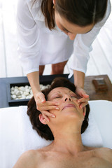 Obraz na płótnie Canvas senior woman having a massage in a spa center