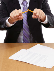 Angry businessman breaking pencil isolated