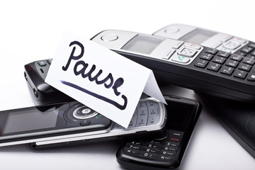 Stapel Telefone und Nachricht mit dem Wort Pause
