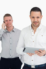 Two smiling men using phone and tablet computer