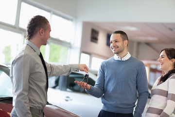 Salesman giving car keys to a couple