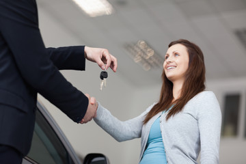 Fototapeta na wymiar Client receiving car keys while shaking hand