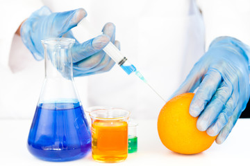 Chemist injecting product in an orange