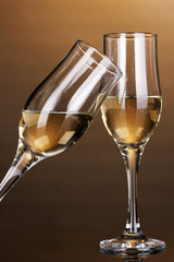Glasses of champagne on brown background