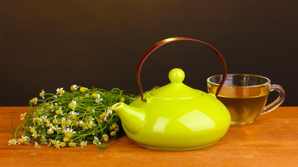 Teapot and cup with chamomile tea