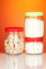 Jars with brown cane sugar lump, white crystal sugar and white