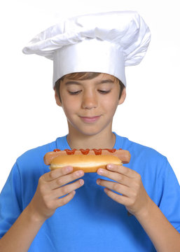 Niño chef sujetando un hotdog,comiendo perro caliente.