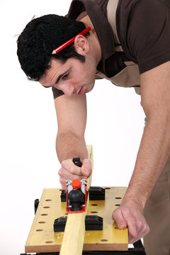 Construction worker using a plane to smooth a surface