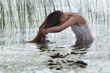 Молодая девушка купается в озере