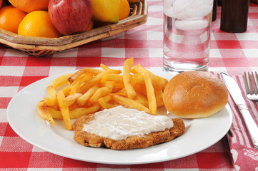 Chicken fried steak with a basket of fruit