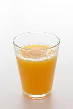 Orange juice in a glass with a white background