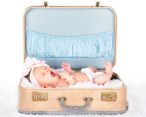 baby yawning in a suitcase