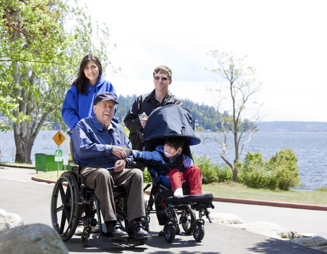 Family with disabled senior and child walking outdoors