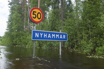 Flooded road with roadsign after heavy rain