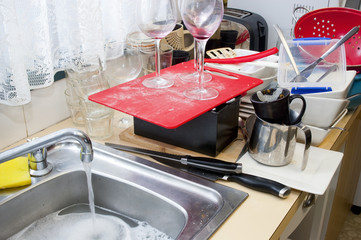 Washing up dirty dishes at the kitchen sink