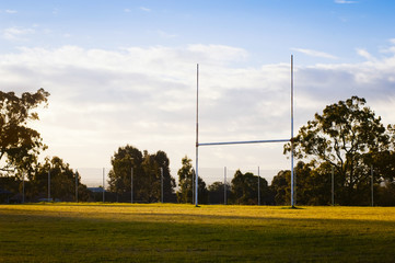 Goal posts for rugby union or rugby league football on a field at sunset in Australia - obrazy, fototapety, plakaty