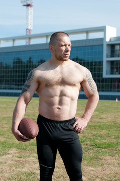 Serious player holding an american football