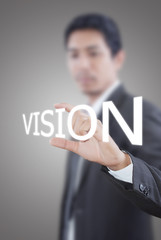 Businessman holding Vision word on the whiteboard.