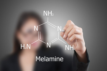 Teacher lady writing scientific formula on the whiteboard.