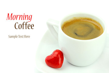 Cup of coffee with a red heart shaped candy isolated on white