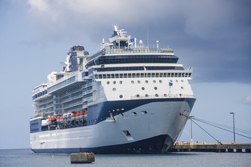Fototapeta na wymiar Blue and White Cruise Ship pod chmurami