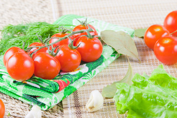 red ripe tomatoes with fresh greenery on a napkin